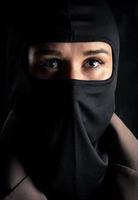 Portrait of a girl in a black balaclava and beige coat. photo