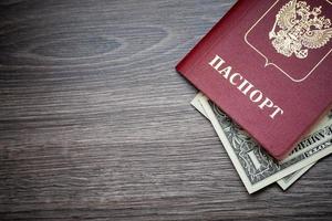 A foreign passport and dollars on a wooden background. photo