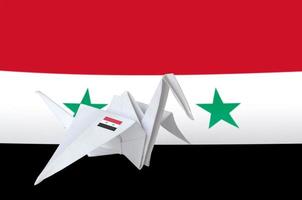 Syria flag depicted on paper origami crane wing. Handmade arts concept