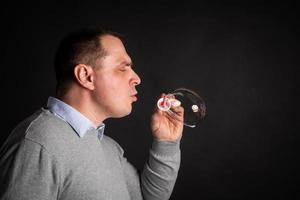 handsome man in a suit is blowing soap bubbles. photo