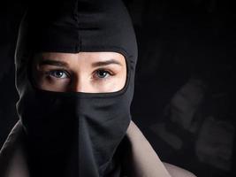 Portrait of a girl in a black balaclava and beige coat. photo