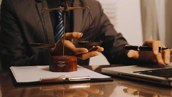 Justice and law concept.Male judge in a courtroom with the gavel, working with, computer and docking keyboard, eyeglasses, on table in morning light video
