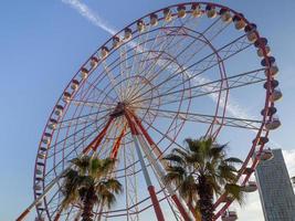 Ferris wheel against the sky. Amusement park on the sea. Rest zone. Ferris wheel. Round mechanism photo