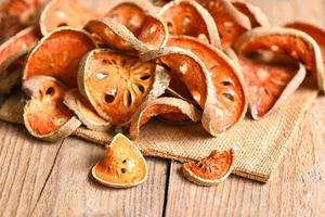 Dried bael slices on wooden background, Bael for bael juice - Dry bael fruit tea for health - Aegle marmelos photo