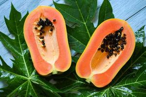papaya fruits on backgroud, fresh ripe papaya slice tropical fruit with papaya seed and leaf leaves from papaya tree photo