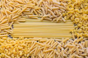 Raw pasta various kinds of uncooked pasta macaroni spaghetti and noodles on wooden, Italian food culinary concept, Collection of different raw pasta on cooking table for cooking food photo