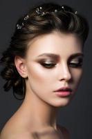 Portrait of young beautiful woman with bridal makeup and coiffure photo