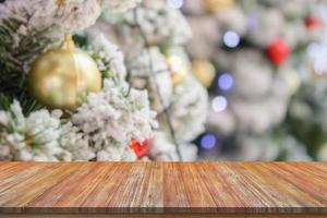 Empty wood table top with blur Christmas tree with bokeh light background photo