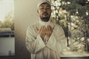 oración del hombre islámico asiático, oración musulmana joven, concepto del festival de ramadán foto