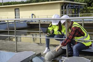 los ingenieros ambientales trabajan en plantas de tratamiento de aguas residuales, la ingeniería de suministro de agua trabaja en la planta de reciclaje de agua para su reutilización, los técnicos y los ingenieros discuten el trabajo juntos. foto