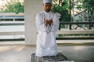 oración del hombre islámico asiático, oración musulmana joven, concepto del festival de ramadán foto