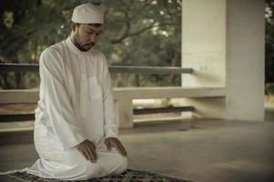 oración del hombre islámico asiático, oración musulmana joven, concepto del festival de ramadán foto