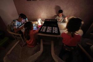 Family spending time together during an energy crisis in Europe causing blackouts. Kids drawing in blackout. photo