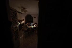 Family spending time together during an energy crisis in Europe causing blackouts. Kids drawing in blackout. photo