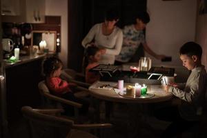 Family spending time together during an energy crisis in Europe causing blackouts. Kids drawing in blackout. photo