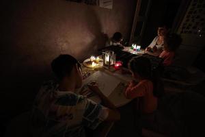 familia pasando tiempo juntos durante una crisis energética en europa que provocó apagones. niños dibujando en apagón. foto