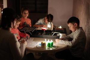 Family spending time together during an energy crisis in Europe causing blackouts. Kids drawing in blackout. photo