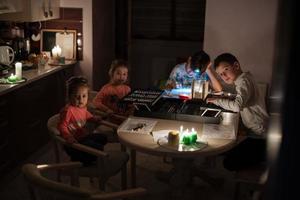 Family spending time together during an energy crisis in Europe causing blackouts. Kids drawing in blackout. photo