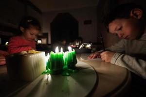 Family spending time together during an energy crisis in Europe causing blackouts. Kids drawing in blackout. photo