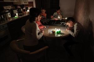 Family spending time together during an energy crisis in Europe causing blackouts. Kids drawing in blackout. photo