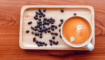 White cup of espresso coffee and Roasted coffee beans on a wooden tray photo
