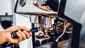 Close-up of hand barista making fresh coffee process of preparing coffee tablet before installing it into the coffee machine photo