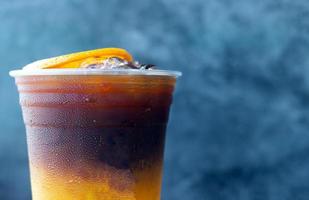 primer plano del menú de bebidas de café helado fusión de naranja americano con fruta fresca de naranja mezclada en un vaso de plástico, producto del menú de bebidas. foto