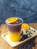 menú de bebida de café helado fusión de naranja americano con fruta fresca de naranja mezclada en una taza de plástico, producto de menú de bebida.