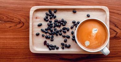 White cup of espresso coffee and Roasted coffee beans on a wooden tray photo