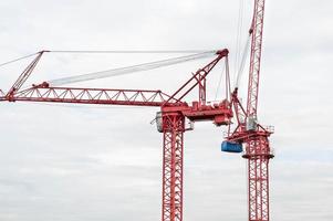 vista del sitio de construcción y grúas rojas para construir una zona residencial moderna, concepto de construcción para la ciudad en desarrollo. foto