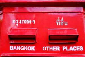 cierre el buzón rojo de correos tailandés. los textos de traducción en la parte superior son bangkok y otros lugares. foto