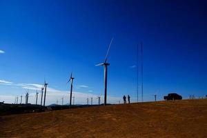 Engineer inspecting wind turbine photo