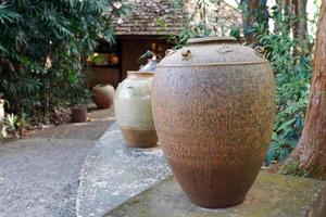 jarrón de terracota marrón frente a otros jarrones dispuestos para decorar el jardín. foto