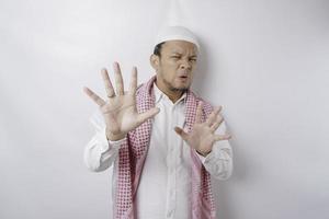 Beautiful Asian Muslim man with hand gesture pose rejection or prohibition with copy space photo