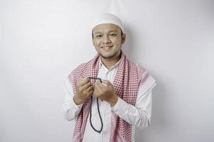 A portrait of a happy Asian Muslim man smiling isolated by white background photo