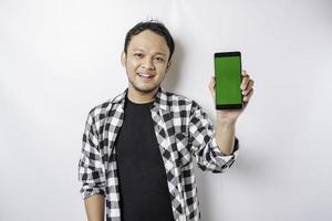 un retrato de un hombre asiático feliz sonríe mientras muestra espacio de copia en su teléfono, aislado por fondo blanco foto