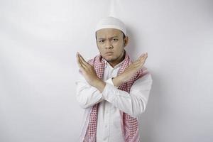 Beautiful Asian Muslim man with hand gesture pose rejection or prohibition with copy space photo