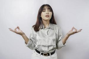 Portrait of a casual pretty woman meditating on white background. Stress free relief at work concept, peaceful young woman practicing breathing yoga exercise photo