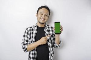 un retrato de un hombre asiático feliz sonríe mientras muestra espacio de copia en su teléfono, aislado por fondo blanco foto