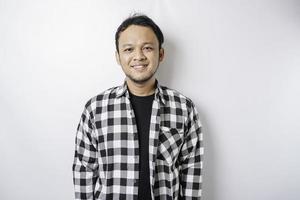 A portrait of a happy Asian man wearing tartan shirt is smiling isolated by white background photo