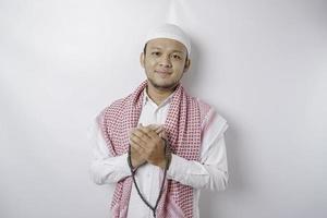 Happy handsome Asian Muslim man is praying to God. photo