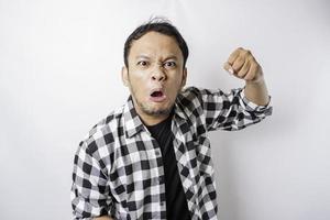 The angry and mad face of Asian man in tartan shirt on isolated white background. photo