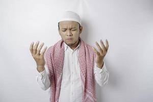 Happy handsome Asian Muslim man is praying to God. photo