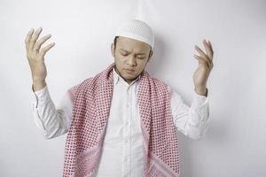 Happy handsome Asian Muslim man is praying to God. photo