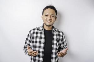 A portrait of a happy Asian man wearing tartan shirt is smiling isolated by white background photo