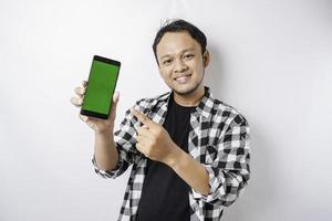 un retrato de un hombre asiático feliz sonríe mientras muestra espacio de copia en su teléfono, aislado por fondo blanco foto