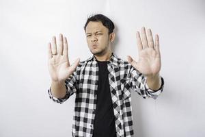 Handsome Asian man with hand gesture pose rejection or prohibition with copy space photo