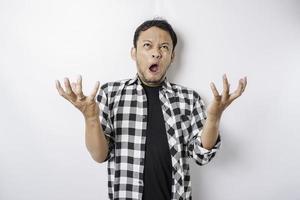 The angry and mad face of Asian man in tartan shirt on isolated white background. photo