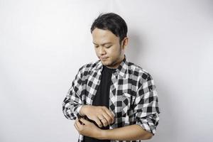 Portrait of a confident smiling Asian man wearing tartan shirt standing with arms folded and looking at the camera isolated over white background photo