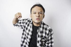 The angry and mad face of Asian man in tartan shirt on isolated white background. photo